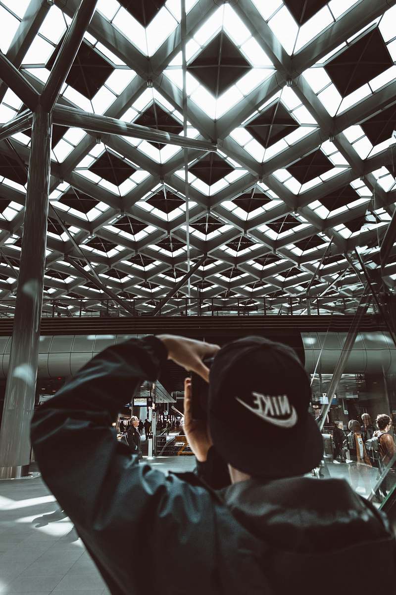 netherlands man wearing black Nike flat brimmed cap holding camera urban